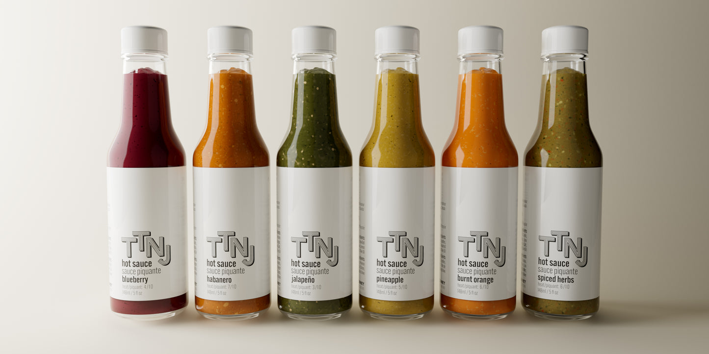 Six bottles of TTNJ hot sauce (Blueberry, Habanero, Jalapeno, Pineapple, Burnt Orange, Spiced Herbs) | To The Next Journey